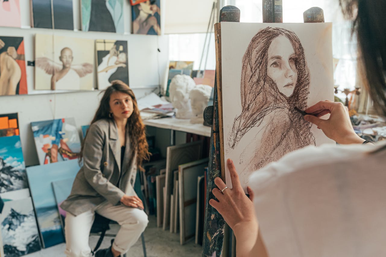 Artist sketching a portrait in a vibrant studio setting with model posing.